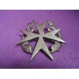 A large metal badge, Maltese Cross with Dolphins