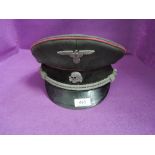 A German SS officers style visor cap with red piping and badges, post war