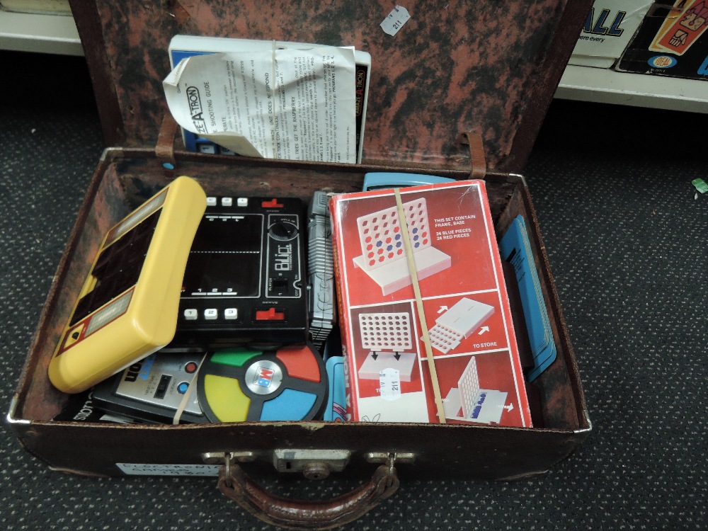 A vintage suitcase containing various electronic games including Blip, Logic 5, AmazeATron etc