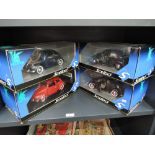 Four Solido Prestige 1:18 scale diecast Beetle cars in red, blue, purple and grey, all in window
