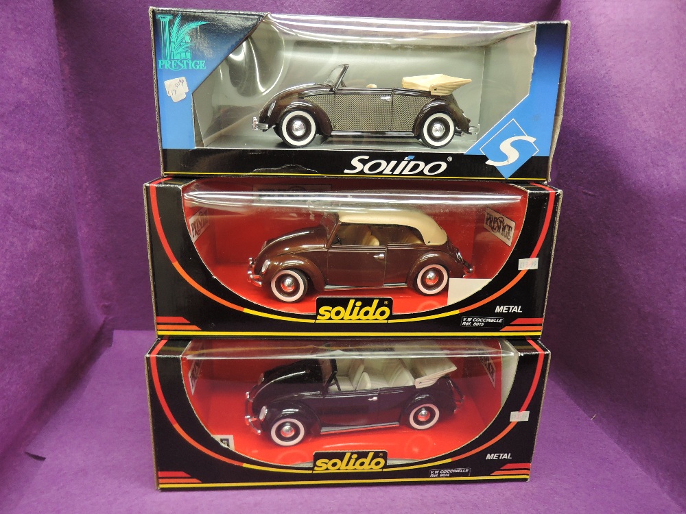 Three Solido Prestige 1:18 scale diecast VW Coccinelle cars in various shades of brown, all in