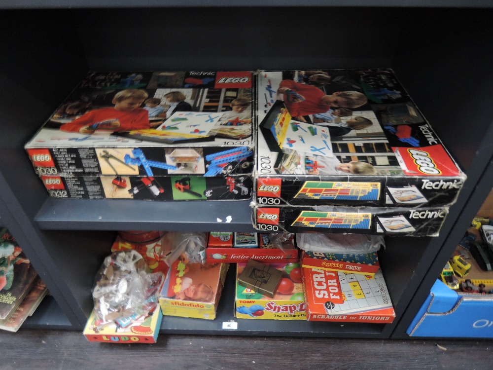 A shelf of vintage games and toys including various board and card games, Dominoes, plastic