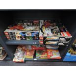 A shelf of vintage games and toys including various board and card games, Dominoes, plastic