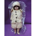 An early 20th century Bisque Headed Doll having fixed glass eyes, fixed open mouth and composition