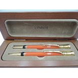 A Parker Duofold propelling pencil and ballpoint pen set in orange, in wooden presentation box