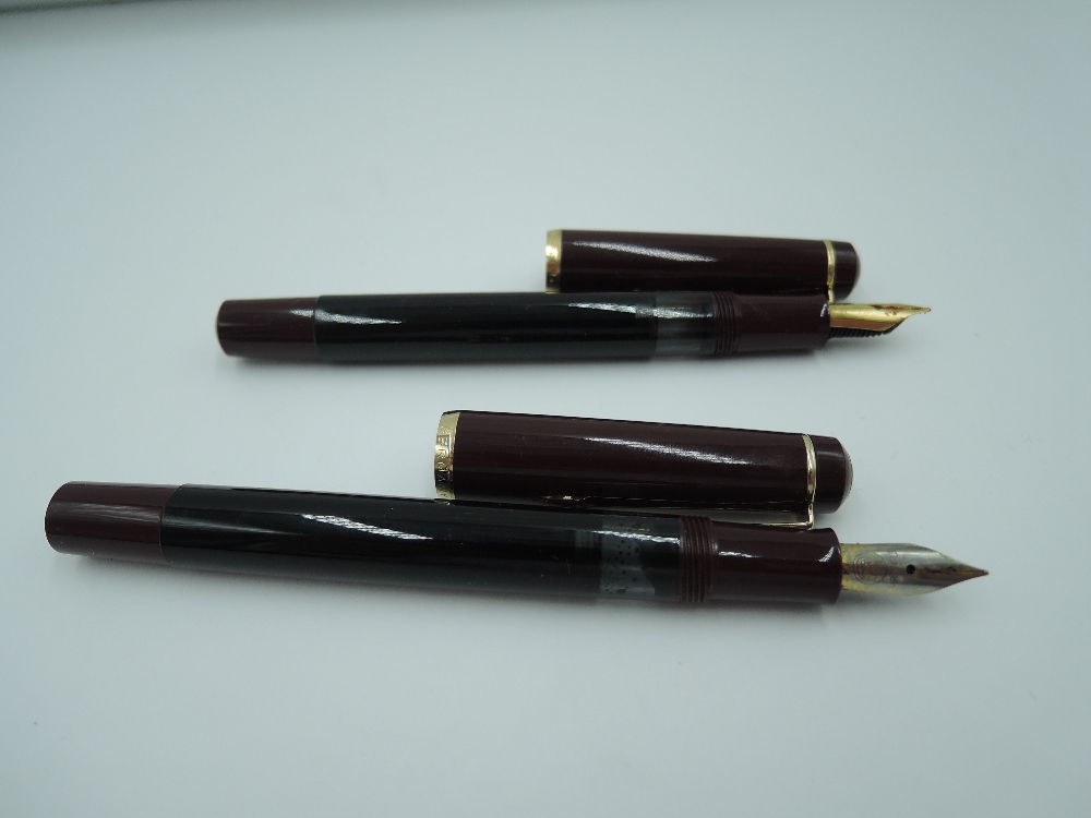 Two Pelikan fountain pens in black and burgundy in soft carry case.