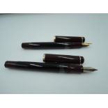 Two Pelikan fountain pens in black and burgundy in soft carry case.
