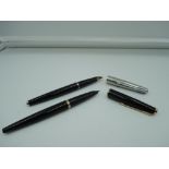 Two Parker fountain pens, Black, one with gold trim and one stainless steel cap, piston fill