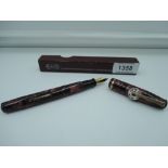 A boxed Wearever de Luxe 100 fountain pen, 1951 red marble, medium nib, lever fill, made in the USA.