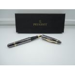 A boxed Peugeot Livery fountain pen, gun metal grey with gold trim, medium/ broad nib, cartridge,