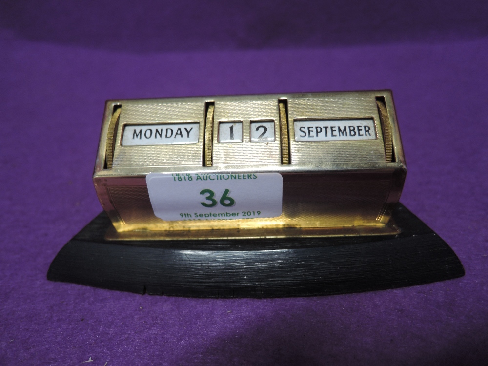 A machine tooled desk top revolving calendar with enamel dials