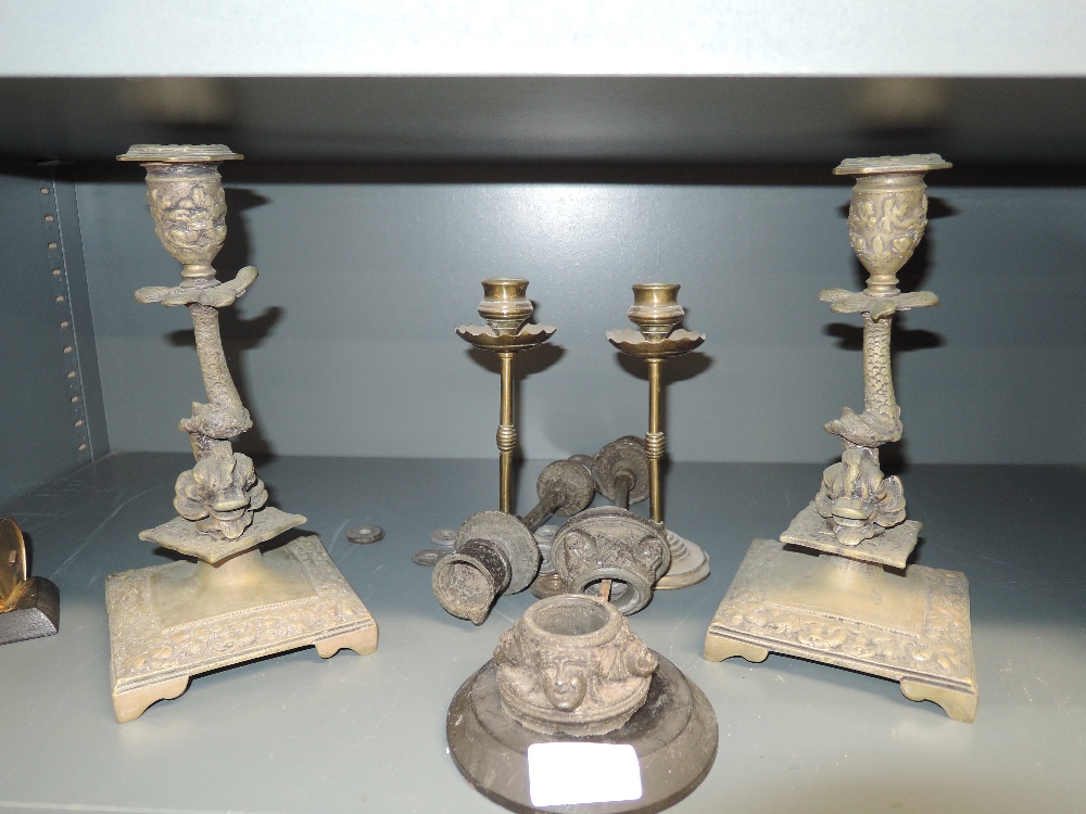 A selection of candle sticks including brass cast and mythical sea creature