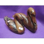 A pair of hand carved wooden swan or duck figures