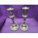 A pair of Sheffield plate weighted candle sticks of classical form having removable sconces, tapered