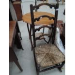 An early 20th century stained frame rocking chair having crest ladder back with rush seat and bobbin