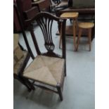 A pair of early 19th century elm vernacular chairs having camel and slat backs with later rush seats