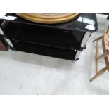 A black glass and chrome TV stand