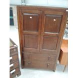 An early to mid 20th Century oak panelled bedroom cabinet