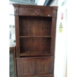 A dark stained bookcase with violin motif and double cupboard under