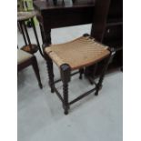 A vintage mahiogany footstool having turned frame