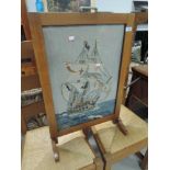 An art deco style fire screen having wool work inset depicting galleon