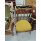 A vintage spindle back armchair, in the Ercol style, part stripped