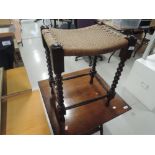 A vintage mahogany footstool having turned frame