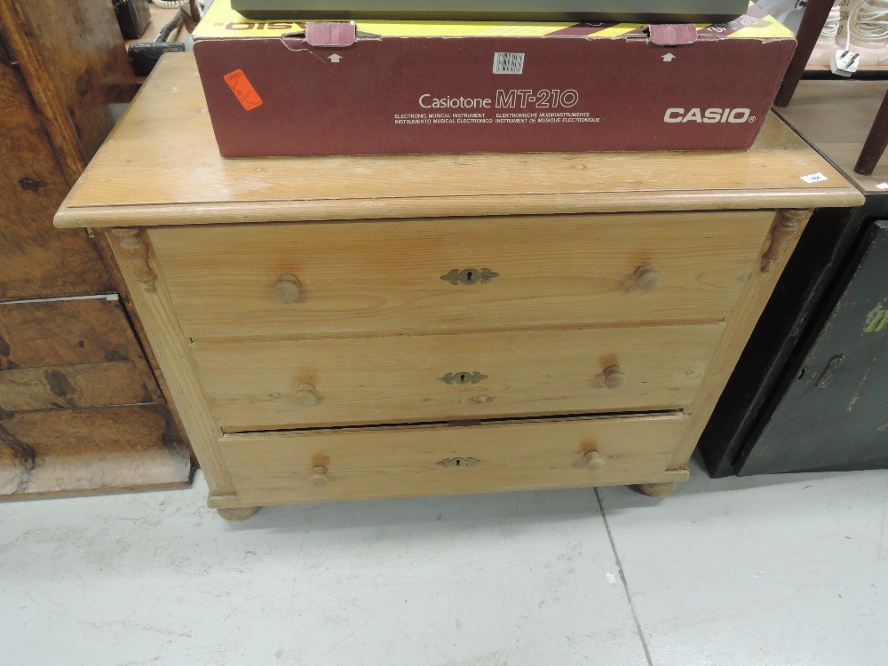 A traditional stripped pine chest of three long drawers