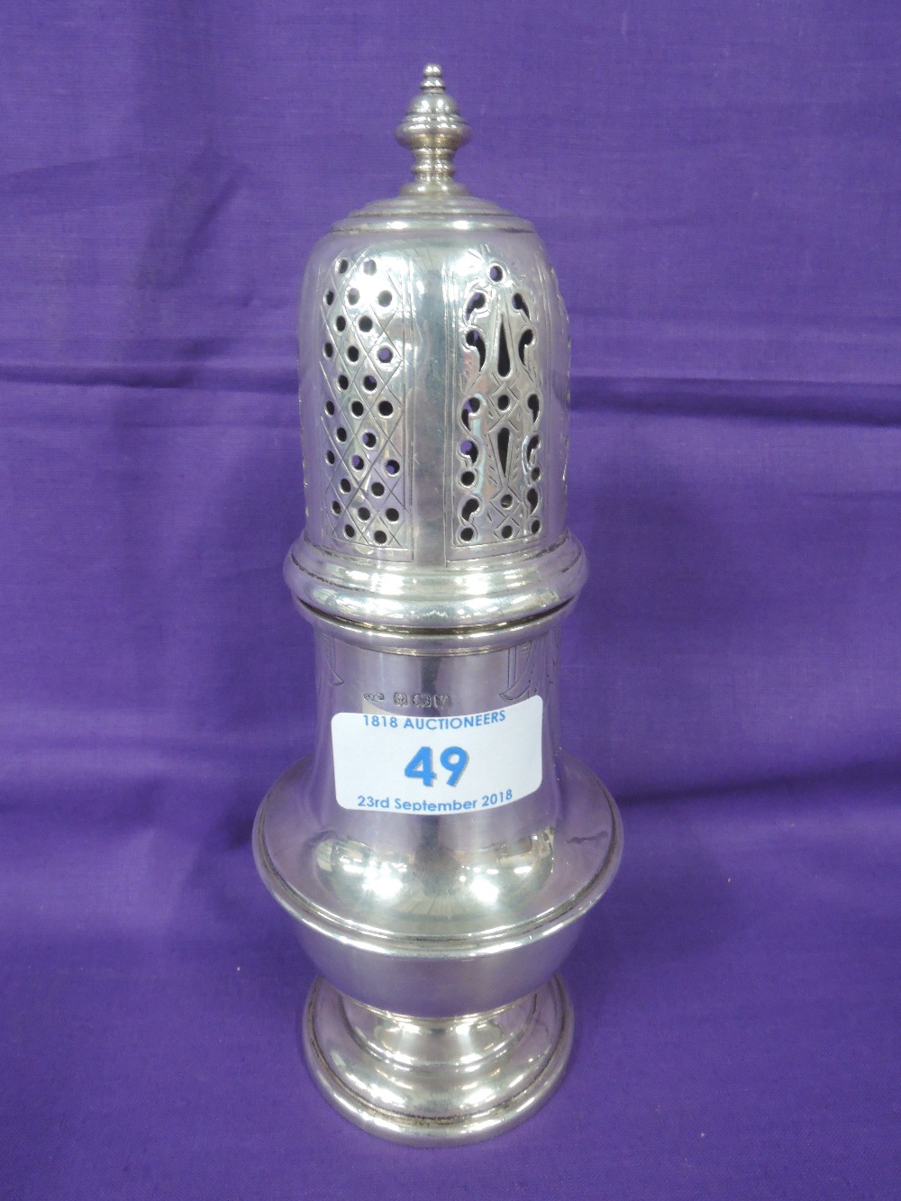 A silver sugar castor of waisted baluster form having pierced lid and engraving to body,