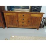 A modern hardwood sideboard central drawer section flanked by cupboards (matches lot 401)