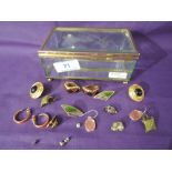 A small glass dressing table box containing a small selection of costume earrings