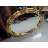 A modern gilt oval wall mirror