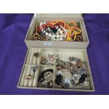 A material cover jewellery box containing a selection of fashion jewellery including beads, rings,