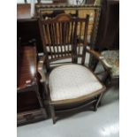 An Edwardian mahogany salon armchair