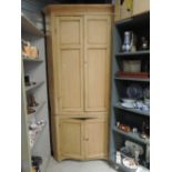 A stripped pine full height corner cupboard