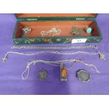 A painted wooden box containing a small selection of white metal jewellery including coin brooch,