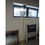 A modern brass standard lamp with green glass shade