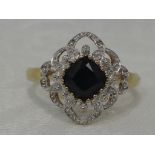 A lady's dress ring having a central sapphire in an open diamond chip set illusionary decorative