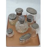 Seven cut and plain glass dressing table pots of various forms and a cut glass perfume bottle, all