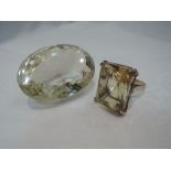 A lady's dress ring having an oversized rectangular citrine in a raised four claw basket mount on