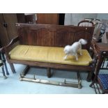 An 18th century oak settle having fielded panel back, with later square seat and turned legs