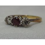A lady's dress ring having a central ruby flanked by two diamonds, each stone approx 0.128ct in a