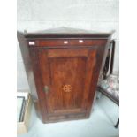 An early 19th century oak and elm corner wall display cabinet having inlay decoration and drawer