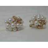 A pair of cultured pearl and diamond chip stylised cluster earrings on 14ct gold stud fittings