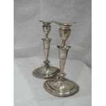 A pair of silver candle sticks of tapered oval form having removable sconces, and weighted stepped