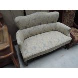 An Edwardian settee having later cream and blue upholstery on tapered legs and spade feet