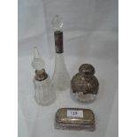 A spherical cut glass perfume bottle having moulded HM silver semi cover and lid bearing cherubic