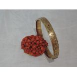 A coral multi bead brooch and a rolled gold hinged bracelet having engraved decoration