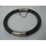 A hinged jade bangle having white metal fittings