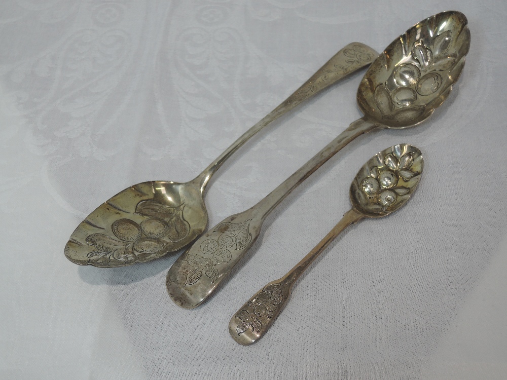 Three Georgian silver berry spoons having bright cut decoration and shaped bowls, London 1802/17/28,